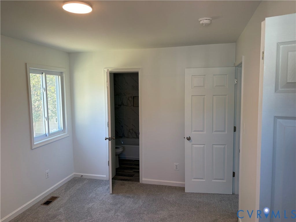 1708 Shewalt Drive, Fairfield, VA 23228 Primary Bedroom Neutral interior space featuring neutral wall-to-wall carpeting, white six-panel interior doors, and a double-hung window
