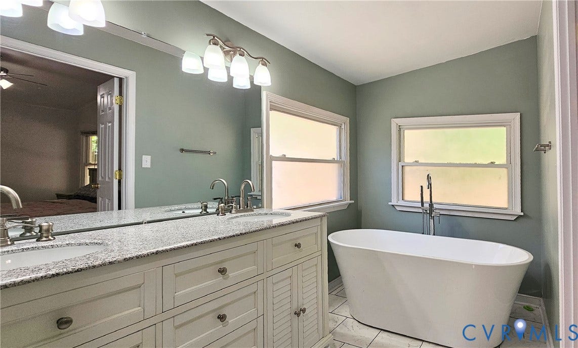 24110 Genito Road, Amelia, VA 23002 Dual-sink vanity with stone-finish countertop, white cabinetry, freestanding soaking tub, chrome fixtures, and tile flooring