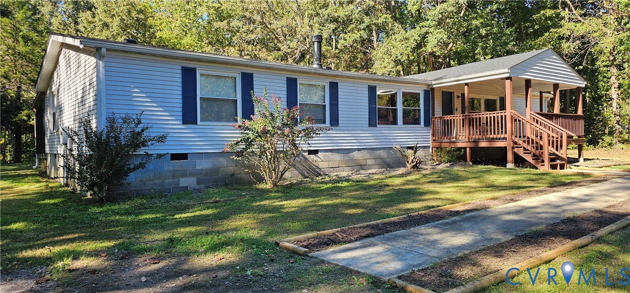 24110 Genito Road, Amelia, VA 23002 Light-colored horizontal siding exterior featuring dark blue window shutters, a concrete masonry unit foundation, and a raised wooden front deck with railings
