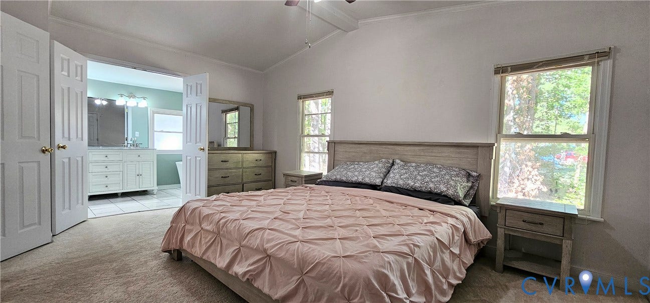 24110 Genito Road, Amelia, VA 23002 Vaulted ceiling with an attached light fixture and neutral wall-to-wall carpeting, featuring dual window placements and double-door entry to the bathroom