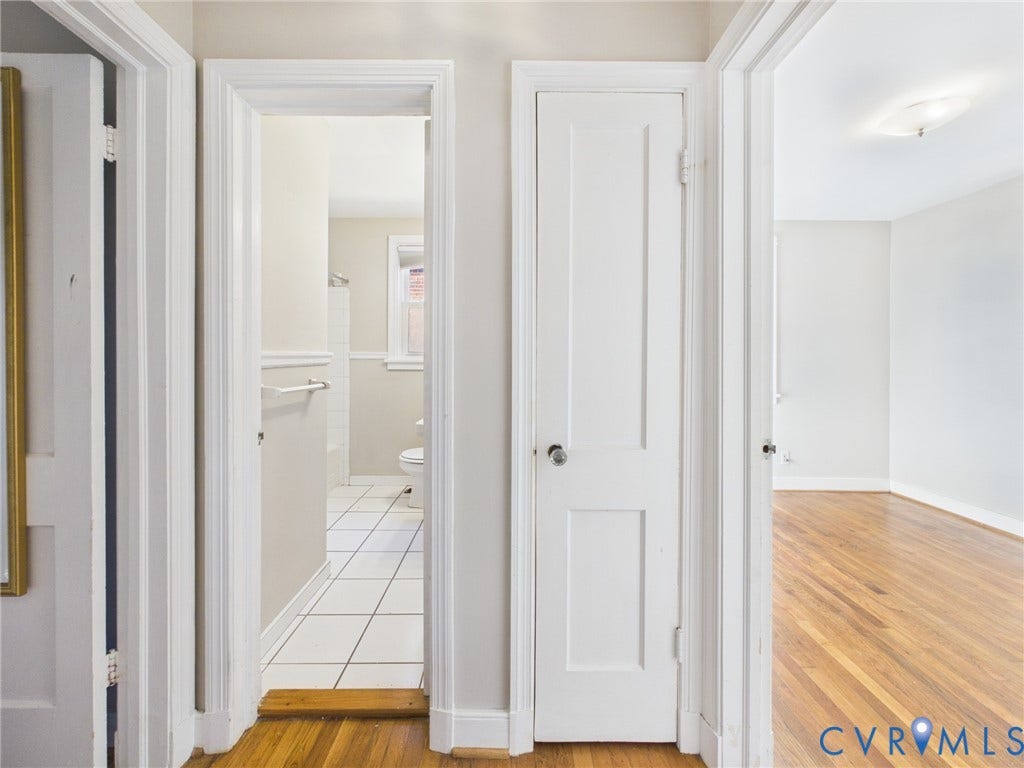 6902 Three Chopt Road, Richmond, VA 23226 Hallway featuring wood-finish flooring, two-panel interior doors, and a built-in storage closet