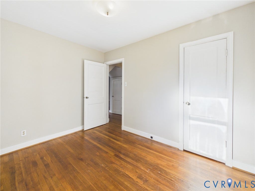 6902 Three Chopt Road, Richmond, VA 23226 Room featuring wood-finish flooring, neutral wall paint, two-panel interior doors, and a ceiling-mounted light fixture