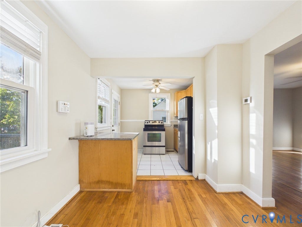 6902 Three Chopt Road, Richmond, VA 23226 Kitchen area featuring wood cabinetry, stainless steel appliances, stone-surface breakfast bar, ceramic tile flooring, and wood-finish flooring