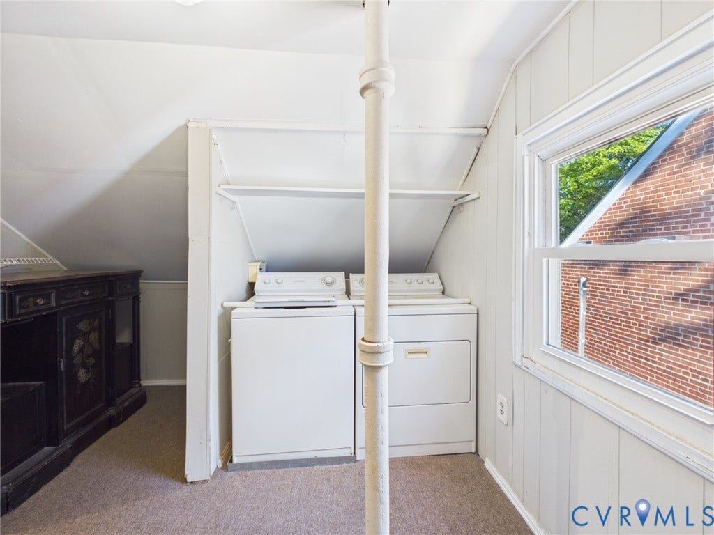 6902 Three Chopt Road, Richmond, VA 23226 Laundry area featuring white washer and dryer units, built-in shelving, vertical wood-paneled walls, and a large window