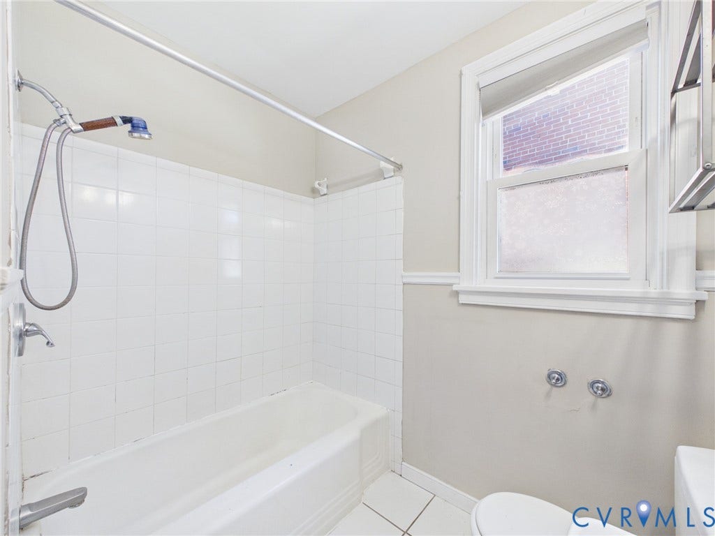 6902 Three Chopt Road, Richmond, VA 23226 Bathroom featuring a white tub-shower combination with ceramic wall tile, a handheld shower fixture, a single-hung window with decorative trim, and tiled flooring