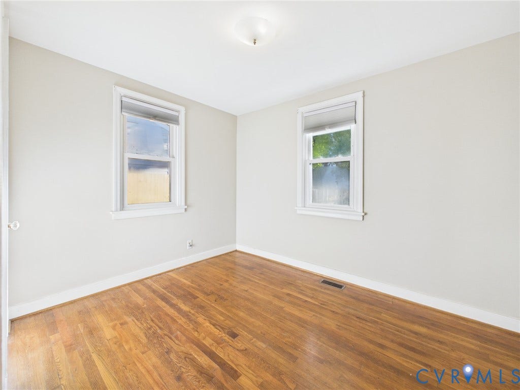 6902 Three Chopt Road, Richmond, VA 23226 Room featuring wood-finish flooring, neutral-toned walls, and two double-hung windows with white trim