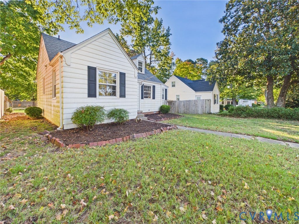6902 Three Chopt Road, Richmond, VA 23226 White siding exterior featuring dark window shutters, a front-facing gable roof, and a brick-bordered landscaping bed