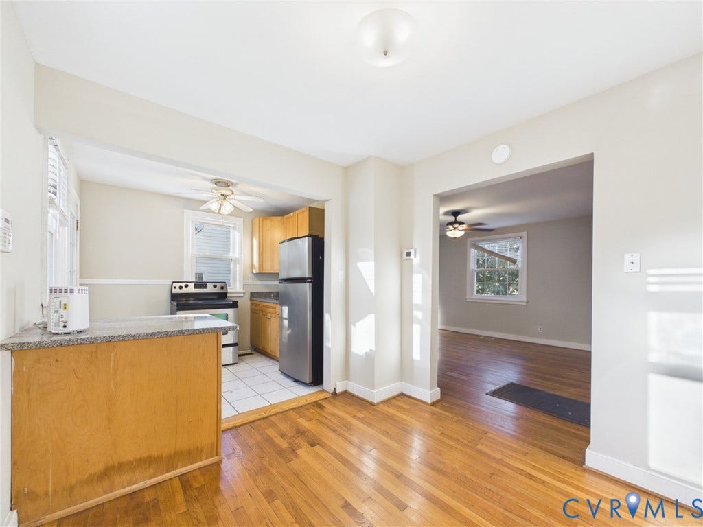 6902 Three Chopt Road, Richmond, VA 23226 Kitchen featuring natural wood cabinetry, stone-finish countertops, stainless steel appliances, and white tile flooring, with wood-finish flooring extending into the additional living area