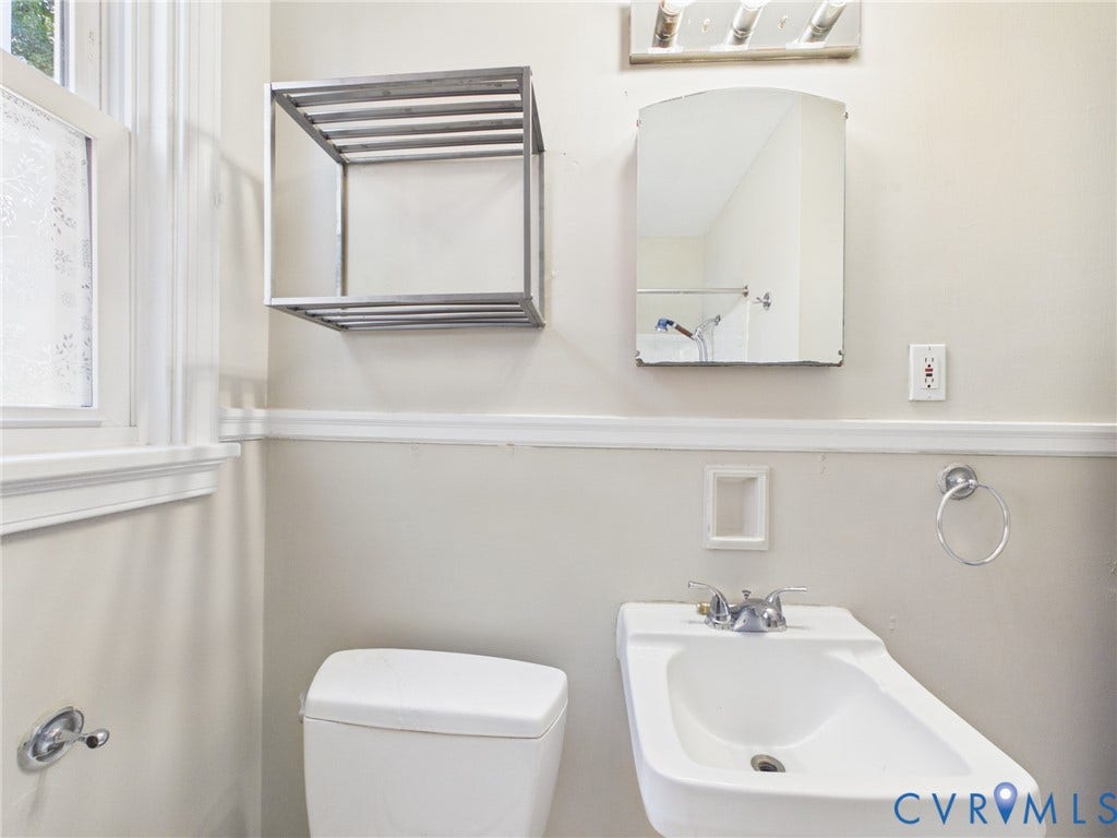 6902 Three Chopt Road, Richmond, VA 23226 Wall-mounted metal storage shelving, wall-mounted mirror, chrome-finished hardware, sink with dual-handle faucet, and chair-height toilet