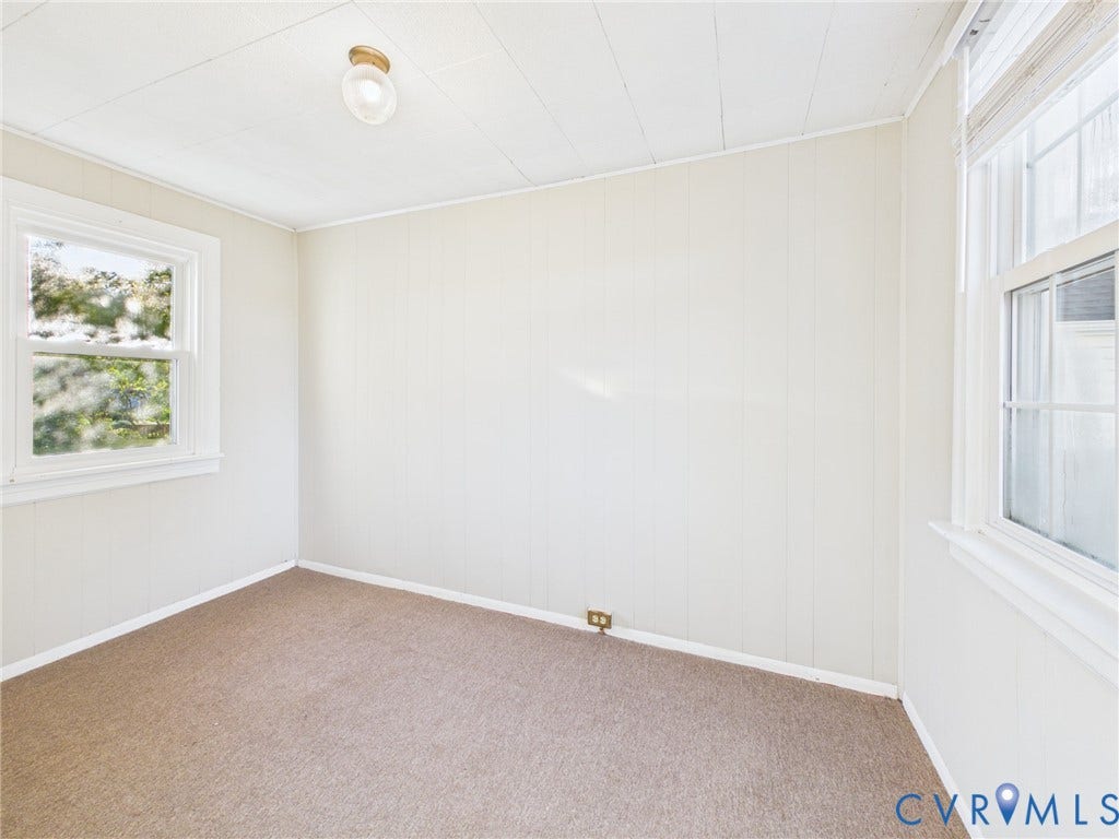 6902 Three Chopt Road, Richmond, VA 23226 Room featuring neutral-toned carpeting, wood-paneled walls, two double-hung windows, and a central ceiling-mounted light fixture