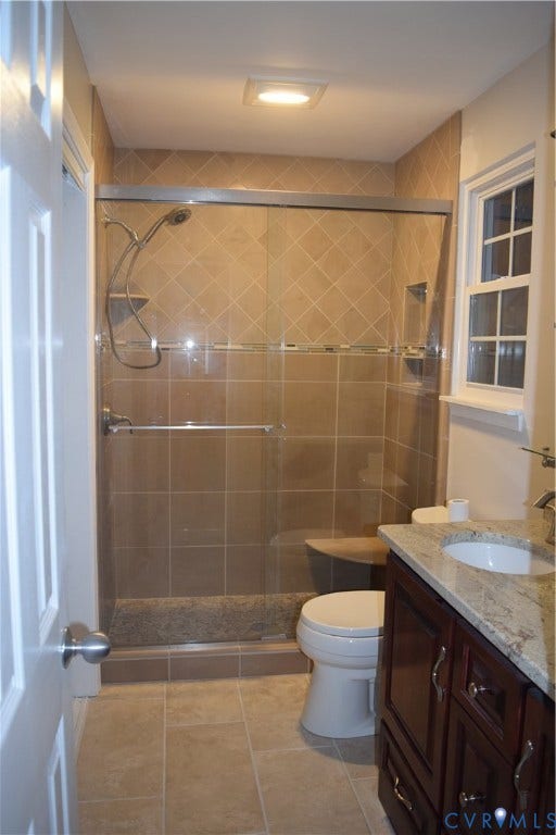 1120 Black Heath Road, Robious/Huguenot, Midlothian, VA 23113 Ensuite Primary Bathroom featuring a walk-in shower with glass sliding doors, stone-finish tile surround, built-in corner shelving and bench, custom counter-height double sink vanity, and granite countertop.