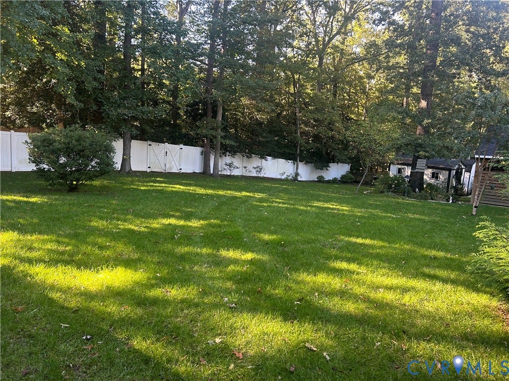 1120 Black Heath Road, Robious/Huguenot, Midlothian, VA 23113 Expansive backyard featuring a level lawn, white vinyl fencing, and mature trees