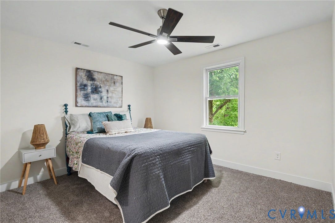 1210 N 24th Street, Church Hill Central, Richmond, VA 23223 Neutral interior featuring wall-to-wall carpeting, a five-blade ceiling fan with integrated lighting, and a double-hung window