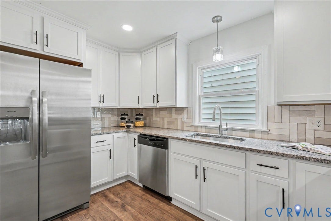 1210 N 24th Street, Church Hill Central, Richmond, VA 23223 Kitchen featuring white shaker-style cabinetry, stainless steel appliances, stone-look countertops, herringbone-patterned tile backsplash, and wood-finish flooring