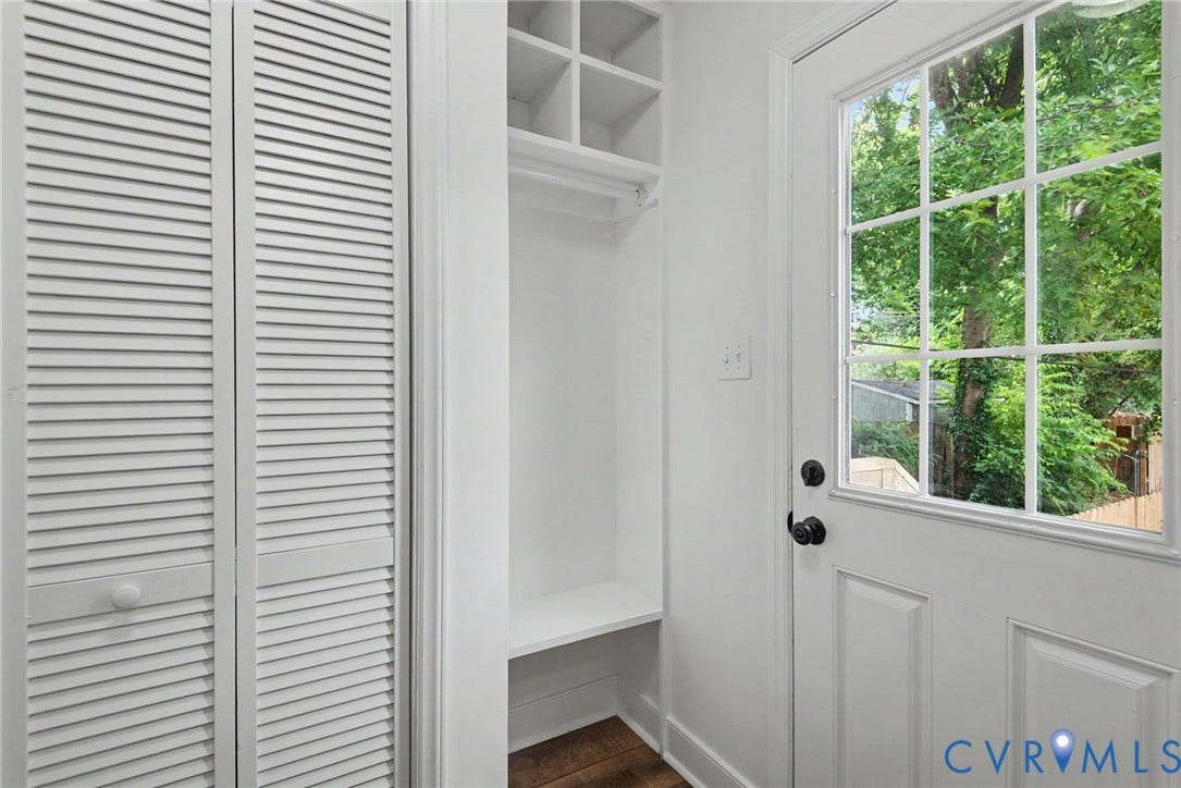 1210 N 24th Street, Church Hill Central, Richmond, VA 23223 Built-in shelving unit with integrated bench seating, white louvered closet doors, wood-finish flooring, and a multi-pane glass door