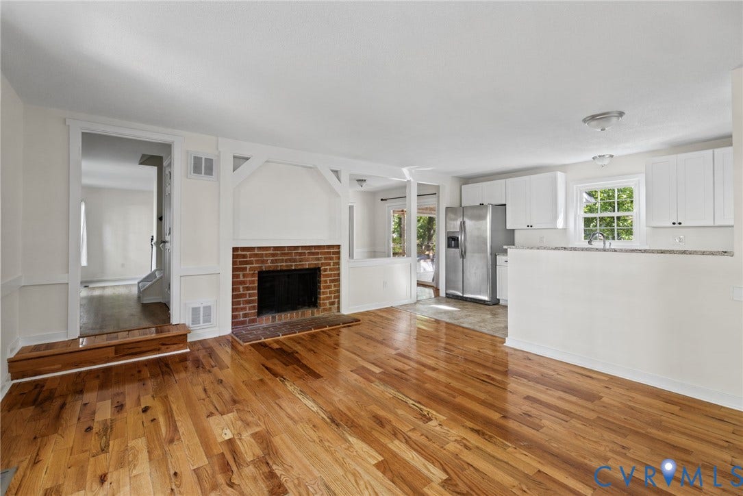 509 Overcliff Court, Walton Park, Midlothian, VA 23114 Wood-finish flooring, brick fireplace with white decorative framing, kitchen with stone-surface countertops, white cabinetry, and stainless steel refrigerator