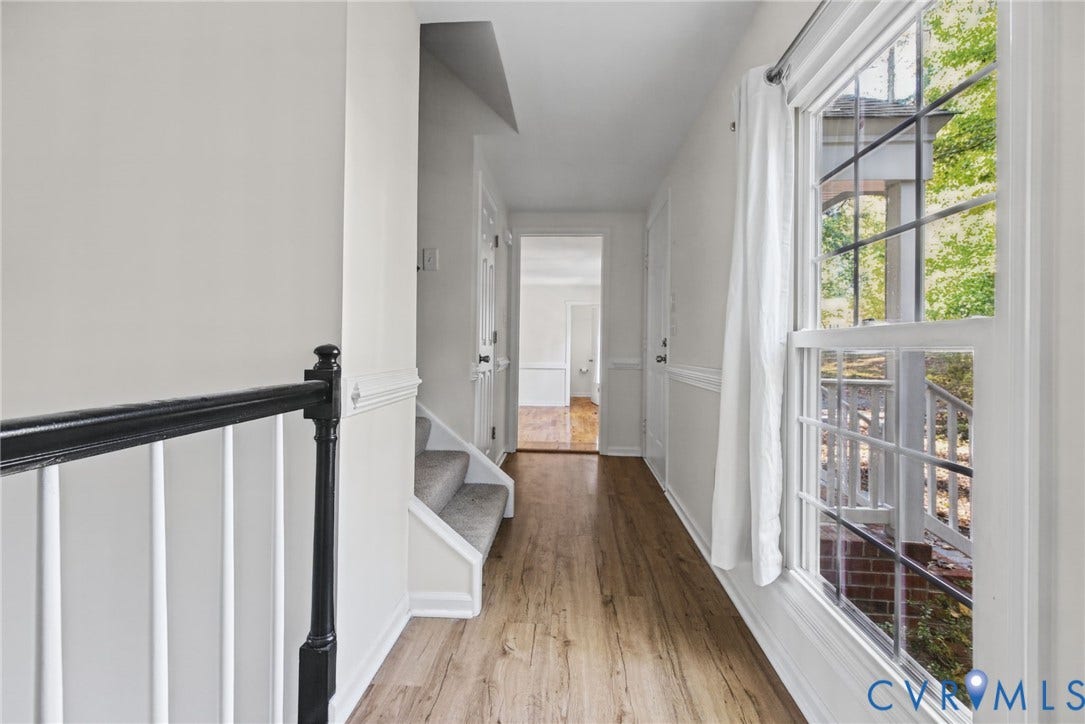 509 Overcliff Court, Walton Park, Midlothian, VA 23114 Hallway featuring wood-finish flooring, chair rail molding, a staircase with a black handrail, and windows with multi-pane grilles