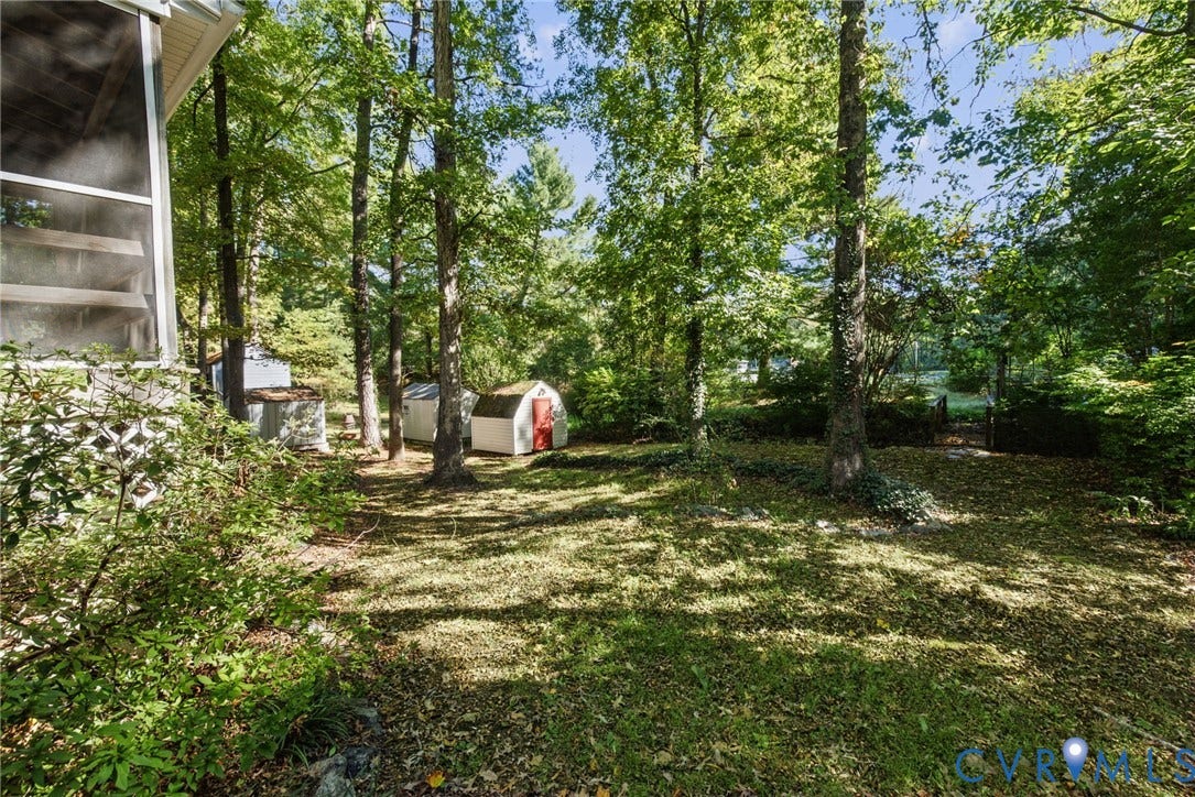 509 Overcliff Court, Walton Park, Midlothian, VA 23114 Wooded backyard featuring a screened porch, multiple storage sheds, and mature trees