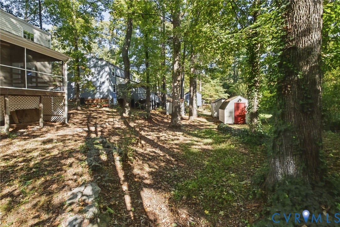 509 Overcliff Court, Walton Park, Midlothian, VA 23114 Wooded backyard featuring a screened-in porch, lattice skirting, and two detached storage sheds