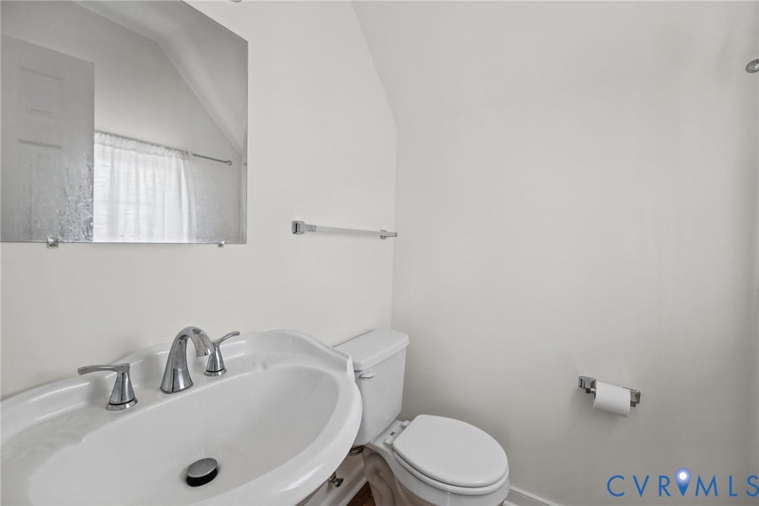 509 Overcliff Court, Walton Park, Midlothian, VA 23114 Wall-mounted frameless mirror, pedestal sink with chrome faucet, and standard toilet fixture
