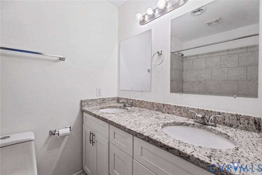 509 Overcliff Court, Walton Park, Midlothian, VA 23114 Dual-sink vanity with a stone countertop, white shaker-style cabinetry, chrome fixtures, and a tiled shower surround