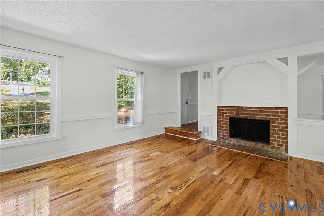 509 Overcliff Court, Walton Park, Midlothian, VA 23114 Living space featuring wood-finish flooring, a red brick fireplace, decorative woodwork detailing, and multiple windows