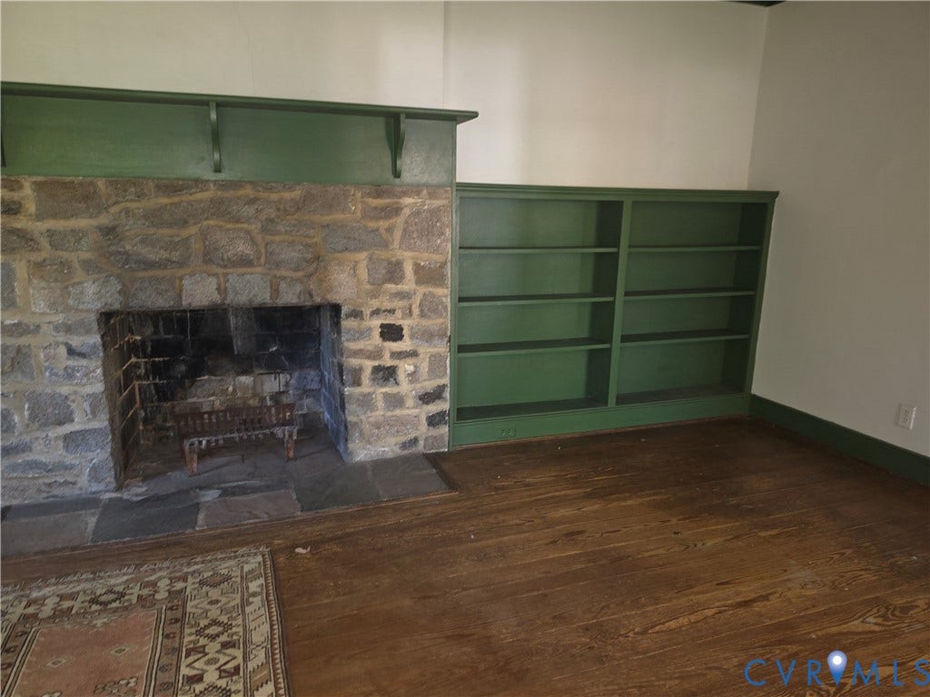 4114 Crestwood Road, Established, Richmond, VA 23227 Stone fireplace with a substantial painted wood mantel, custom built-in shelving, slate hearth, and dark wood-finish flooring