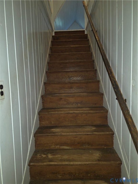 4114 Crestwood Road, Established, Richmond, VA 23227 Staircase featuring wood treads, vertical paneled wall treatments, and a mounted wooden handrail