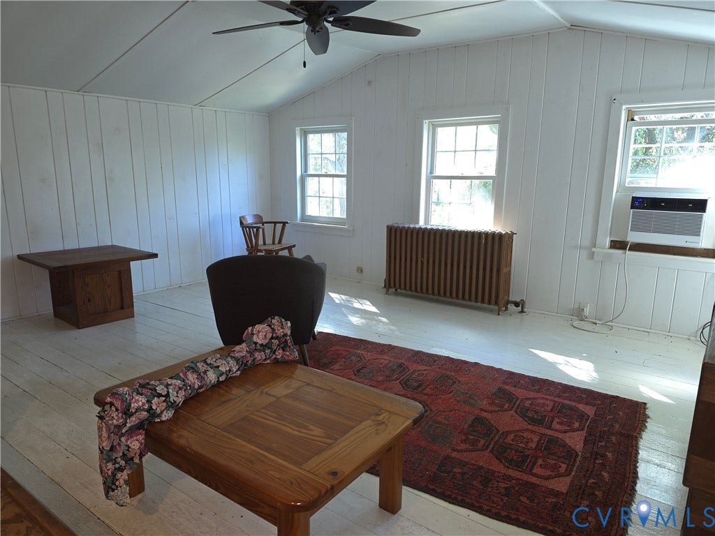 4114 Crestwood Road, Established, Richmond, VA 23227 Vaulted ceilings with vertical paneling, painted wood-finish flooring, multi-pane windows, and a classic cast-iron radiator
