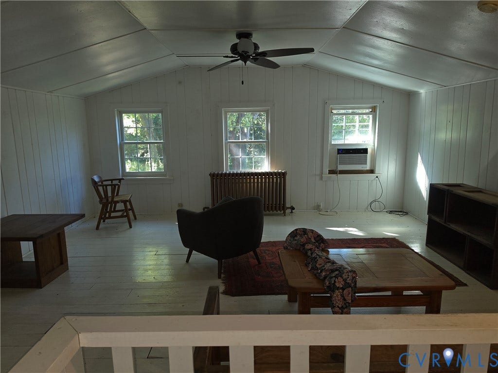 4114 Crestwood Road, Established, Richmond, VA 23227 Vaulted ceiling with vertical wood-paneled walls, multiple windows, metal radiator, and ceiling fan