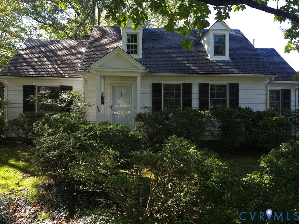 4114 Crestwood Road, Established, Richmond, VA 23227 Raised Ranch/Cape Cod exterior featuring white horizontal siding, dark decorative shutters, a peaked entry portico, and two dormer windows