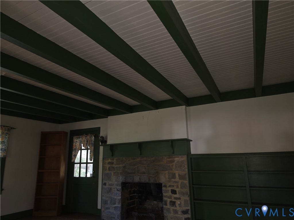 4114 Crestwood Road, Established, Richmond, VA 23227 Exposed dark-finished ceiling beams with white beadboard paneling, floor-to-ceiling stone fireplace, and built-in wood shelving
