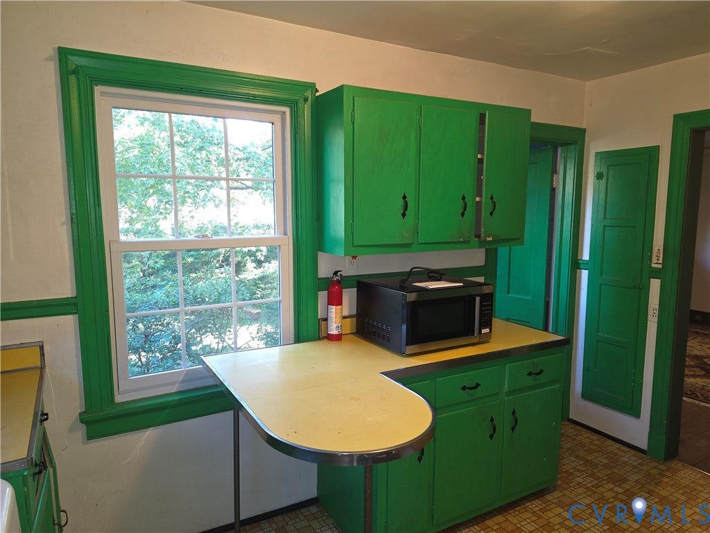4114 Crestwood Road, Established, Richmond, VA 23227 Kitchen featuring wood cabinetry, integrated countertop with metal edging, double-hung window, built-in wall paneling, and patterned flooring