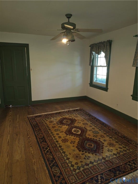 4114 Crestwood Road, Established, Richmond, VA 23227 Room featuring wood-finish flooring, a multi-panel door with dark trim, dual windows with decorative casing, and a ceiling-mounted light fixture with fan