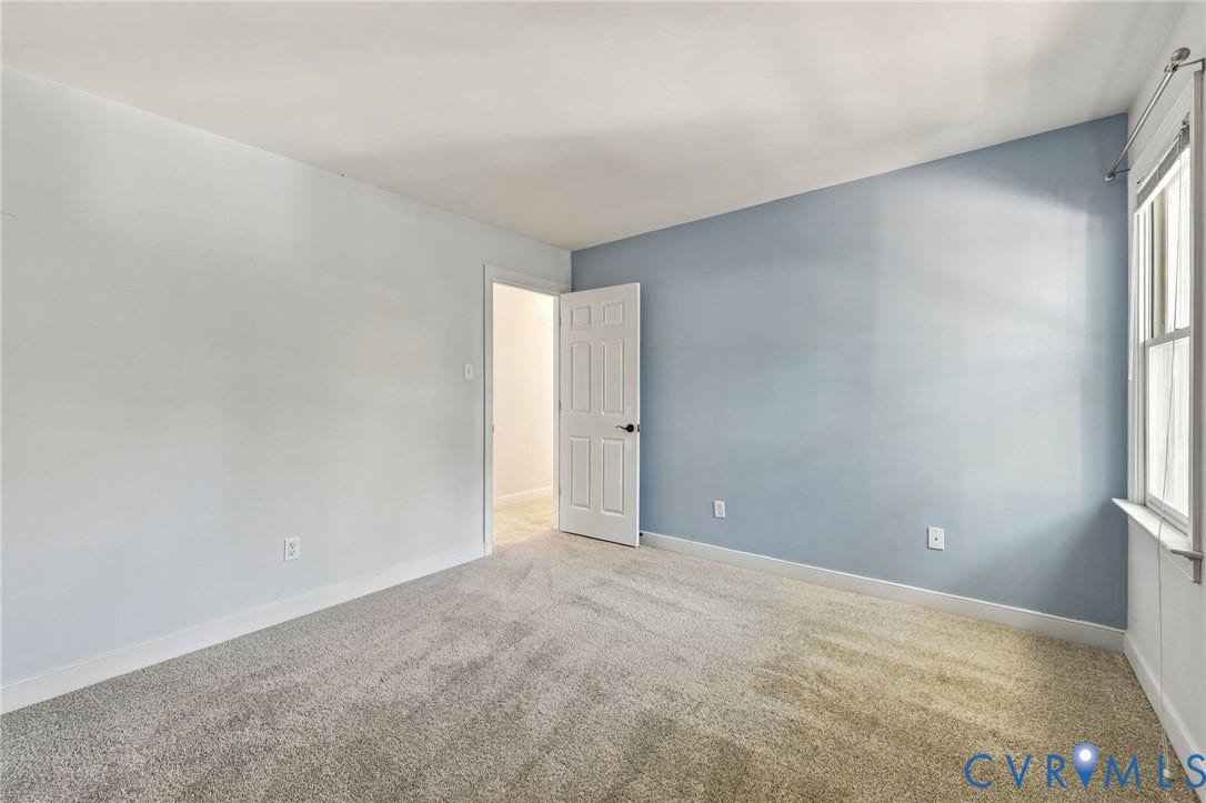 4712 Cedar Forest Road, Glen Allen, VA 23060 Generously sized bedroom featuring a soft blue accent wall, natural light, and flexible furniture placement.