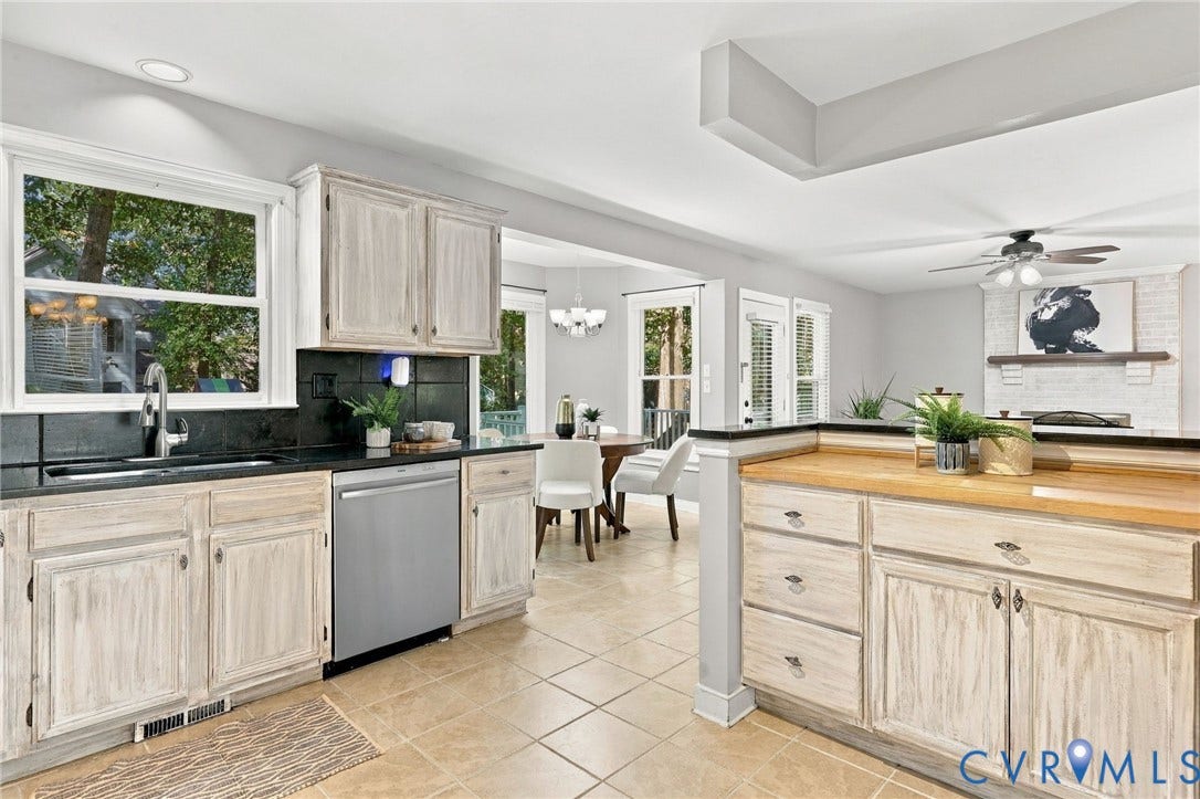 4712 Cedar Forest Road, Glen Allen, VA 23060 Spacious kitchen featuring distressed-finish cabinetry, dark countertops, stainless steel appliances, and a convenient breakfast bar overlooking the family room.