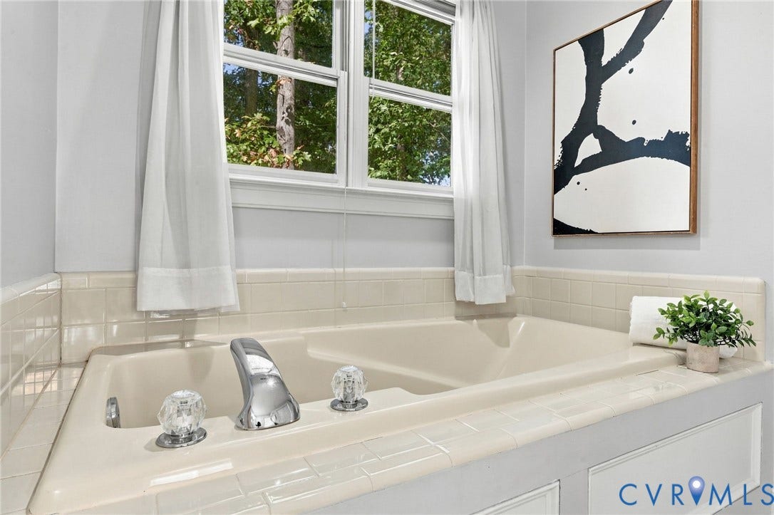 4712 Cedar Forest Road, Glen Allen, VA 23060 Relaxing soaking tub with tile surround and a large window overlooking the surrounding greenery.