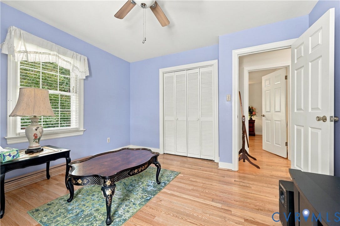 8307 Wallingford Lane, Chickahominy Bluffs, Henrico, VA 23227 Room featuring wood-finish flooring, a multi-pane window with a valance, louvered bi-fold closet doors, and a ceiling-mounted fan
