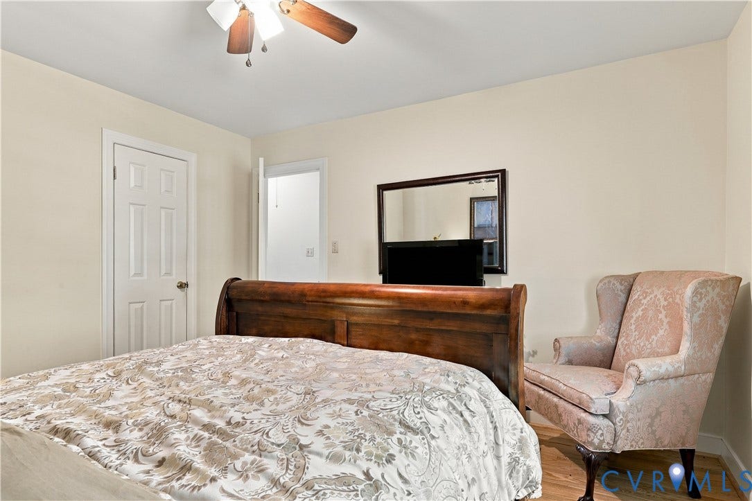 8307 Wallingford Lane, Chickahominy Bluffs, Henrico, VA 23227 Neutral-toned interior walls featuring a six-panel door, light wood-finish flooring, and a ceiling-mounted light fixture with a three-blade fan