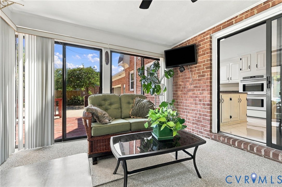 8307 Wallingford Lane, Chickahominy Bluffs, Henrico, VA 23227 Sunroom featuring exposed brick walls, expansive floor-to-ceiling windows, and multiple glass sliding doors