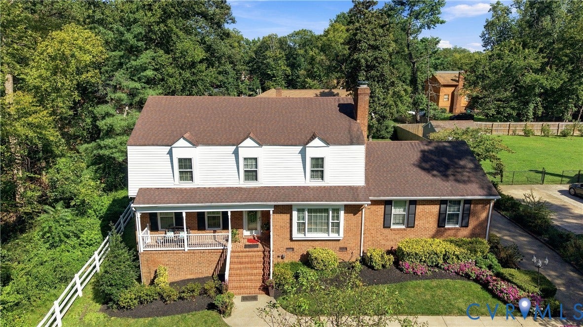 8307 Wallingford Lane, Chickahominy Bluffs, Henrico, VA 23227 Two-story brick and siding exterior featuring a covered front porch, gabled roofline, multi-pane windows, and extensive mature landscaping
