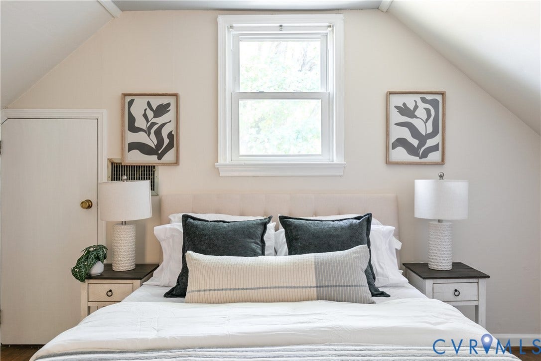 Room featuring sloped ceilings, a centered single-hung window, and a white interior door