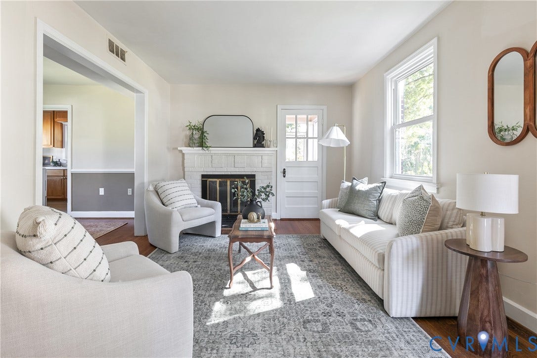 Living space featuring a brick fireplace, wood-finish flooring, multi-pane window, and an exterior door with glass detailing