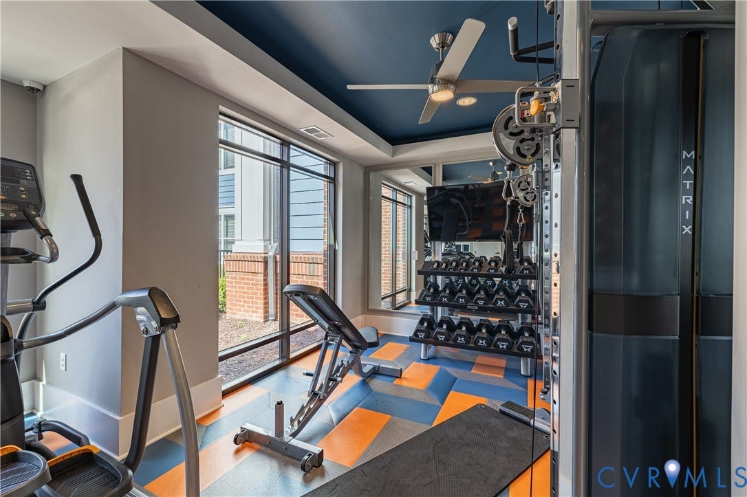 10525 Stony Bluff Drive, #107, Stony Run Condos, Ashland, VA 23005 Fitness center featuring floor-to-ceiling windows, mirrored wall, patterned synthetic flooring, and a recessed ceiling with a central fan