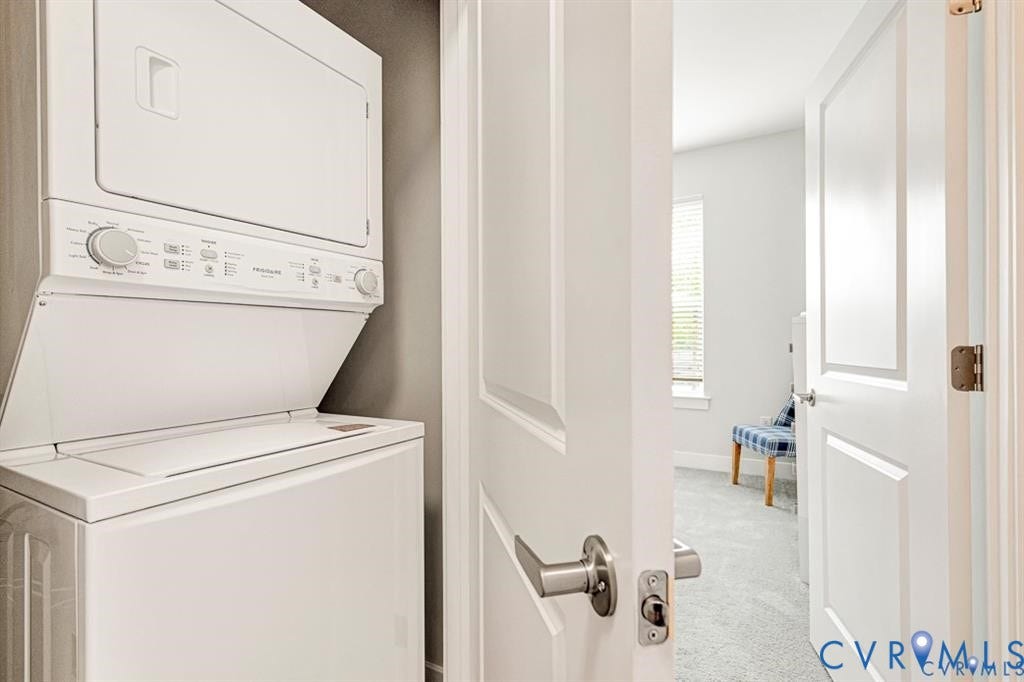 10525 Stony Bluff Drive, #107, Stony Run Condos, Ashland, VA 23005 Stacked laundry unit featuring white appliances, recessed into a dedicated alcove with neutral-tone wall surfacing, accessible via a solid-core interior door with a brushed nickel lever handle