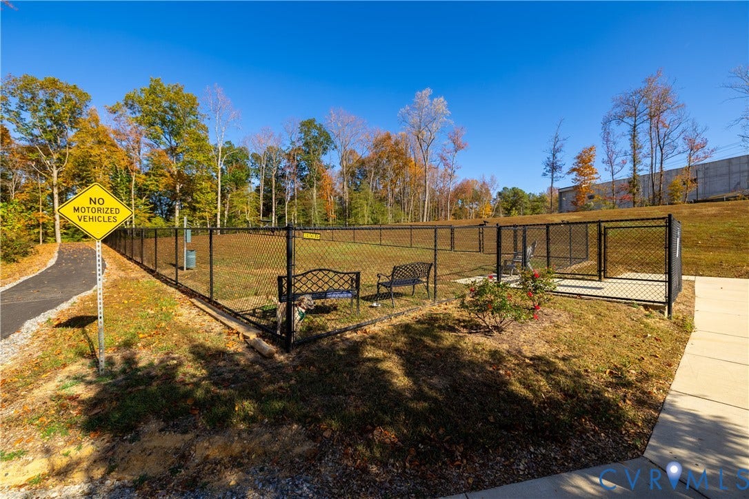 10525 Stony Bluff Drive, #107, Stony Run Condos, Ashland, VA 23005 Fenced outdoor enclosure featuring a chain-link perimeter, paved walking path, and mature tree line