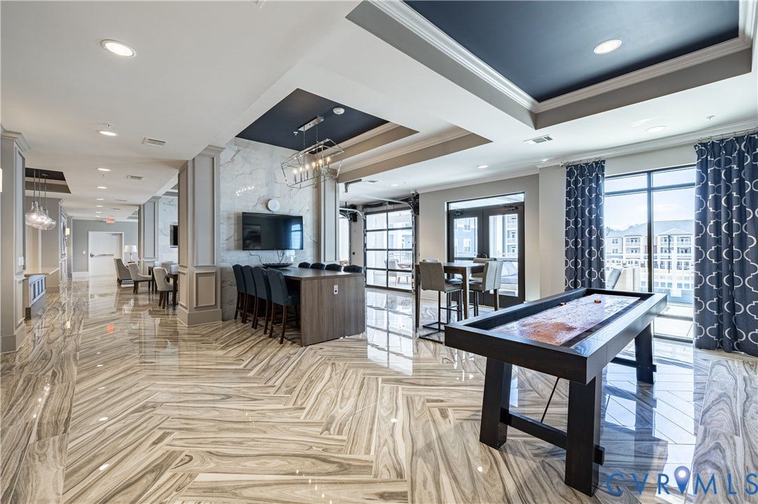 10525 Stony Bluff Drive, #107, Stony Run Condos, Ashland, VA 23005 Polished stone flooring in a herringbone pattern, coffered ceilings with recessed lighting, integrated stone-clad wall feature, and glass-paneled garage-style door
