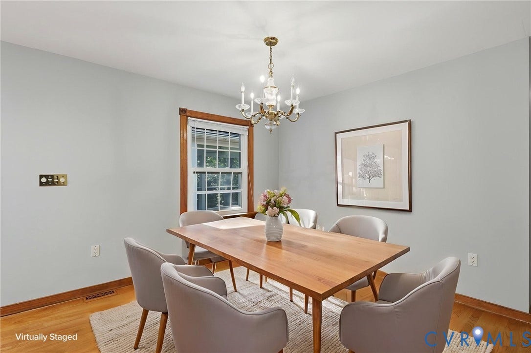 Dining room featuring wood-finish flooring, multi-pane window with wood trim, and a multi-arm chandelier