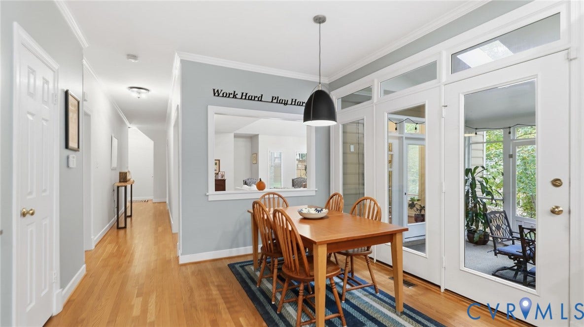 2040 Normandstone Drive, Roxshire, Midlothian, VA 23113 Dining area featuring wood-finish flooring, a contemporary pendant light fixture, a pass-through wall opening, and multi-pane glass doors with transom windows