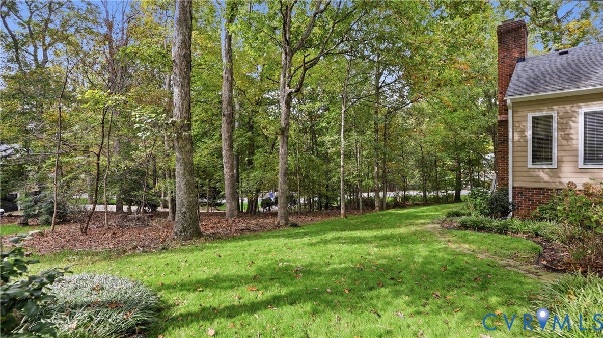 2040 Normandstone Drive, Roxshire, Midlothian, VA 23113 Expansive yard featuring a manicured lawn, mature trees, and a brick exterior chimney